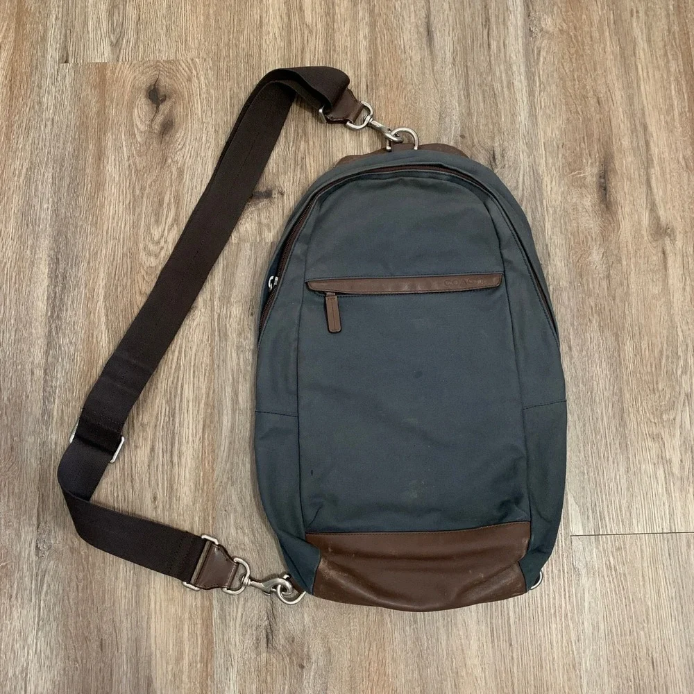 Coach 2013 canvas sling backpack in navy blue w/ brown leather panels - 13x18in